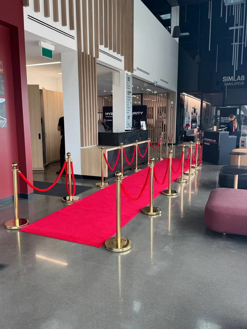 A red runner edged with gold posts and ropes crossing a shopping centre floor