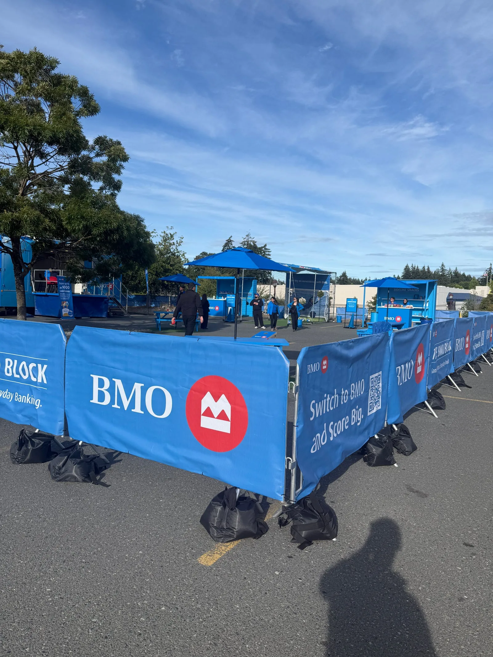 Barricades in blue printed skirting weighted with sandbags at an outdoor community event