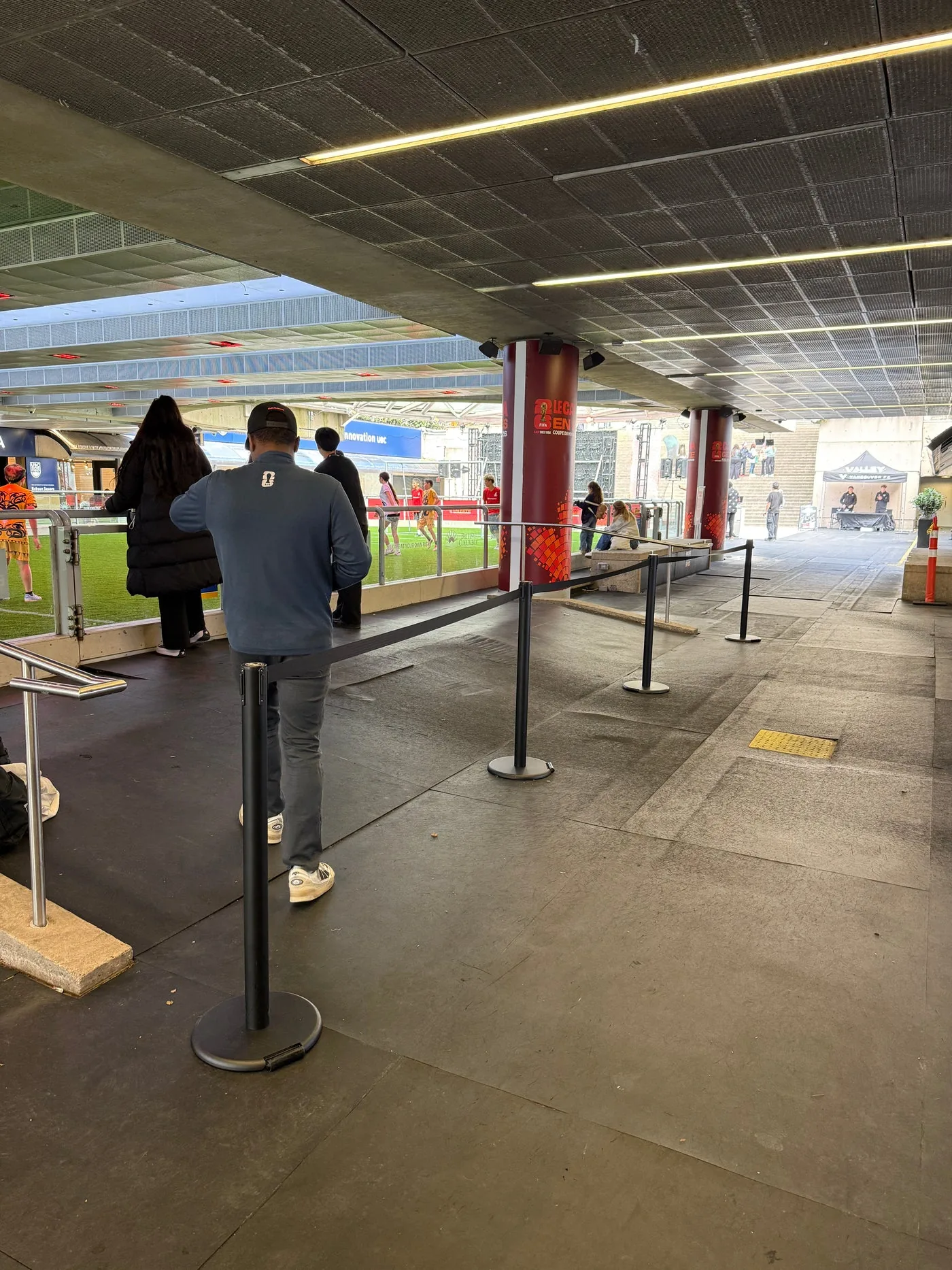 A black belt post directing a queue under the canopy of a transit entrance