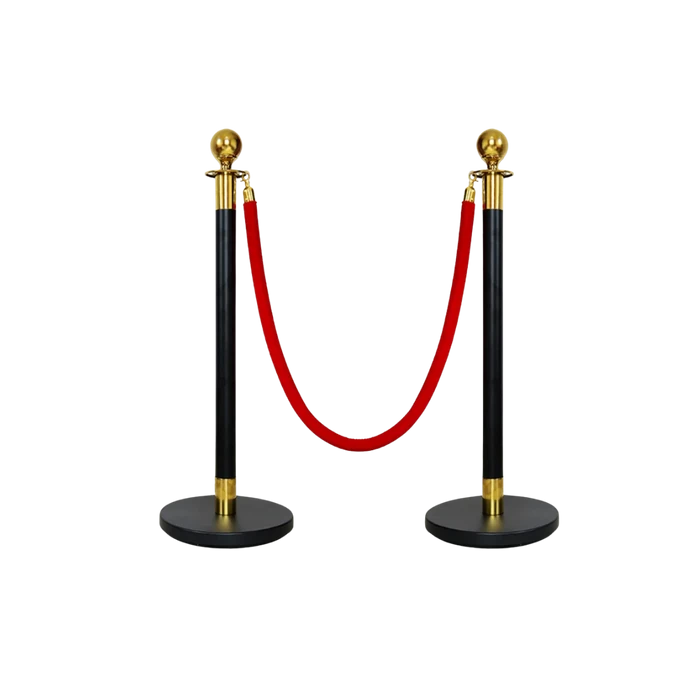 A pair of black rope stanchions with gold caps, linked by a red velvet rope