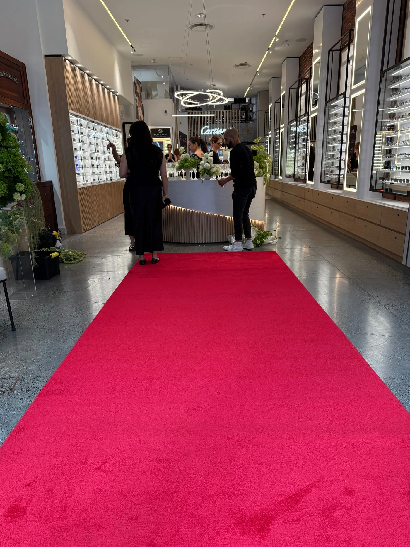 A red runner laid the length of a bright retail arcade towards a reception desk